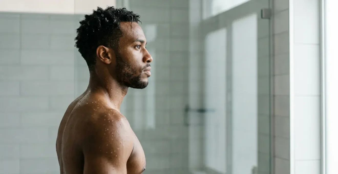 Person experiencing cold shower therapy for immune system strengthening in modern wellness setting