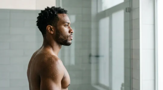 Person experiencing cold shower therapy for immune system strengthening in modern wellness setting