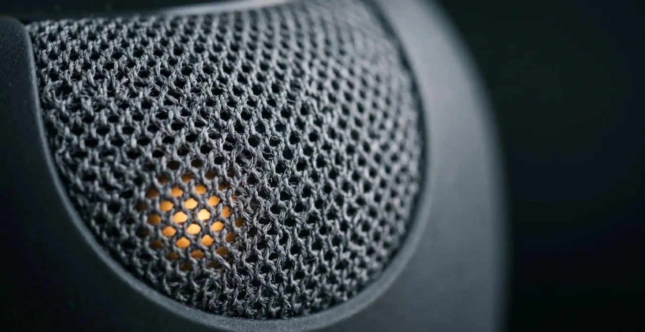 Macro close-up of smart speaker microphone mesh surface with ambient LED indicator light
